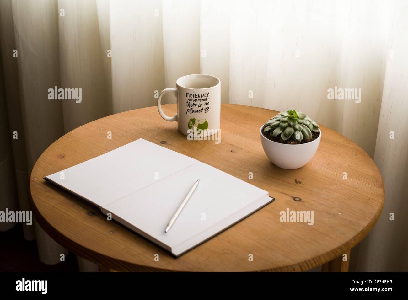 Minimalist work space at home, with cup of coffee and open blank notebook on top of the desk Stock Photo