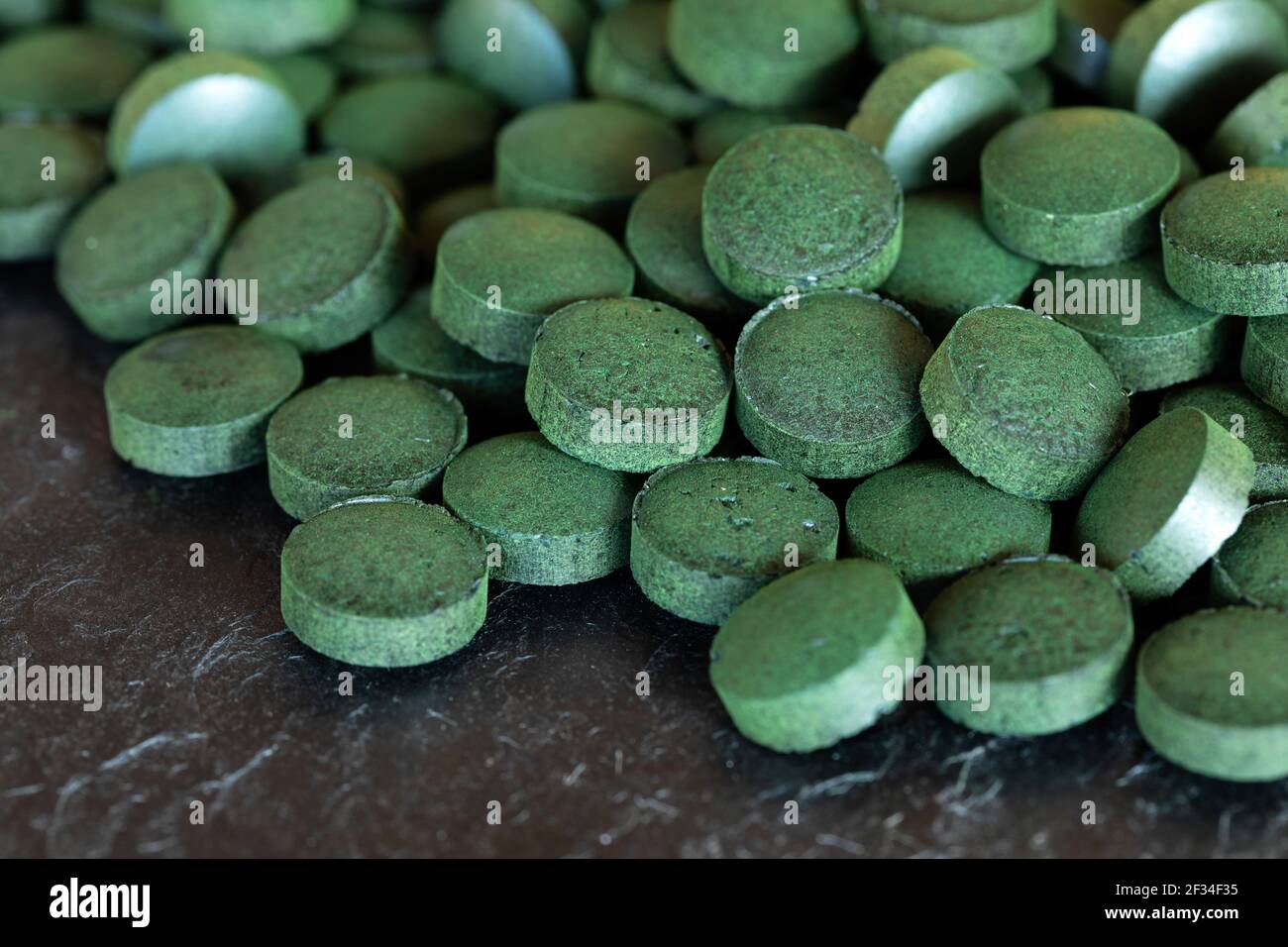 Spirulina green pills on slate plate Stock Photo Alamy