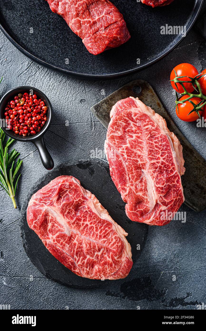 Raw top blade oyster Steak on stone and meat butcher cleaver, marbled