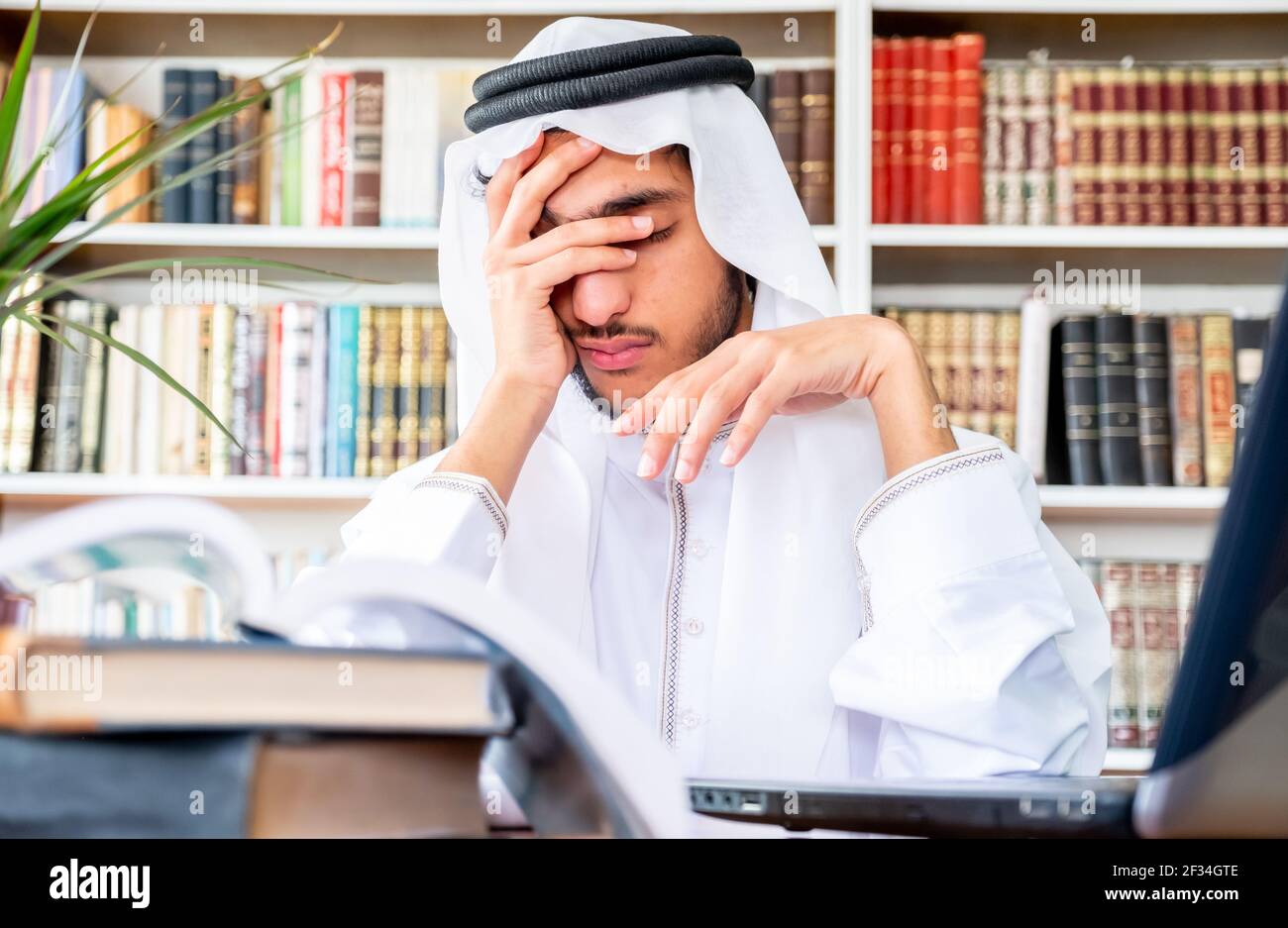 Arabic Muslim man feeling upset while studying online Stock Photo