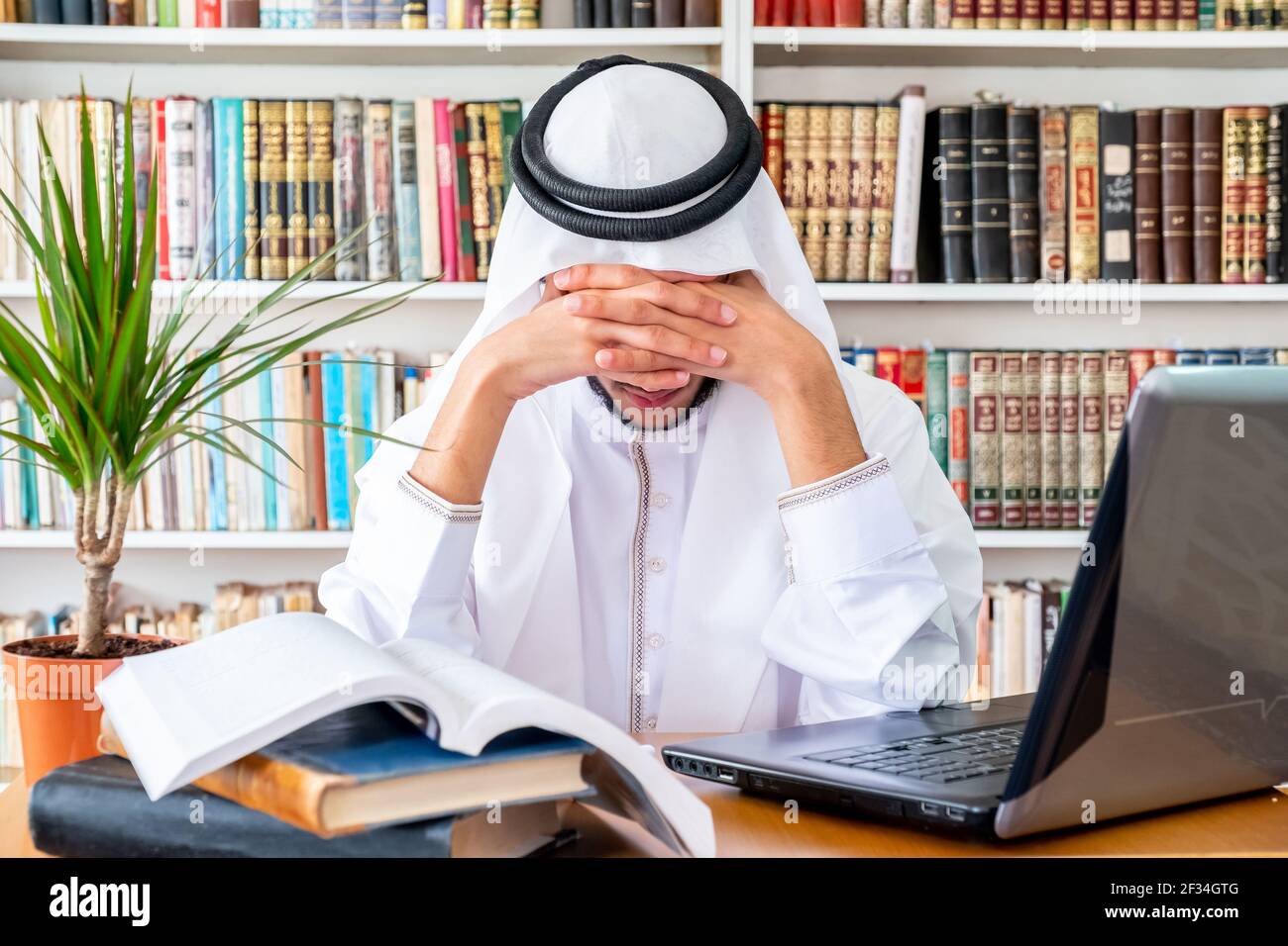 Arabic Muslim man feeling upset while studying online Stock Photo