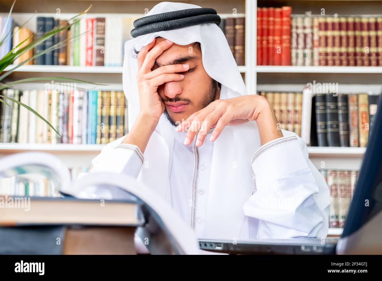 Arabic Muslim man feeling upset while studying online Stock Photo