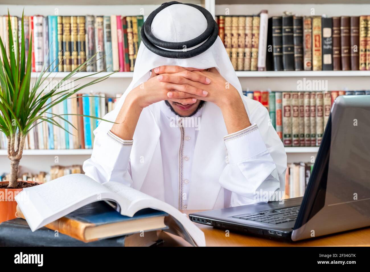 Arabic Muslim man feeling upset while studying online Stock Photo