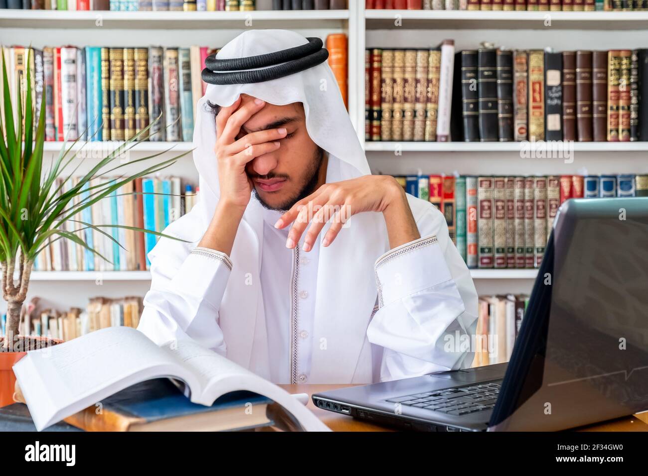 Arabic Muslim man feeling upset while studying online Stock Photo