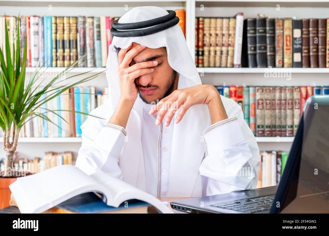 Arabic Muslim man feeling upset while studying online Stock Photo