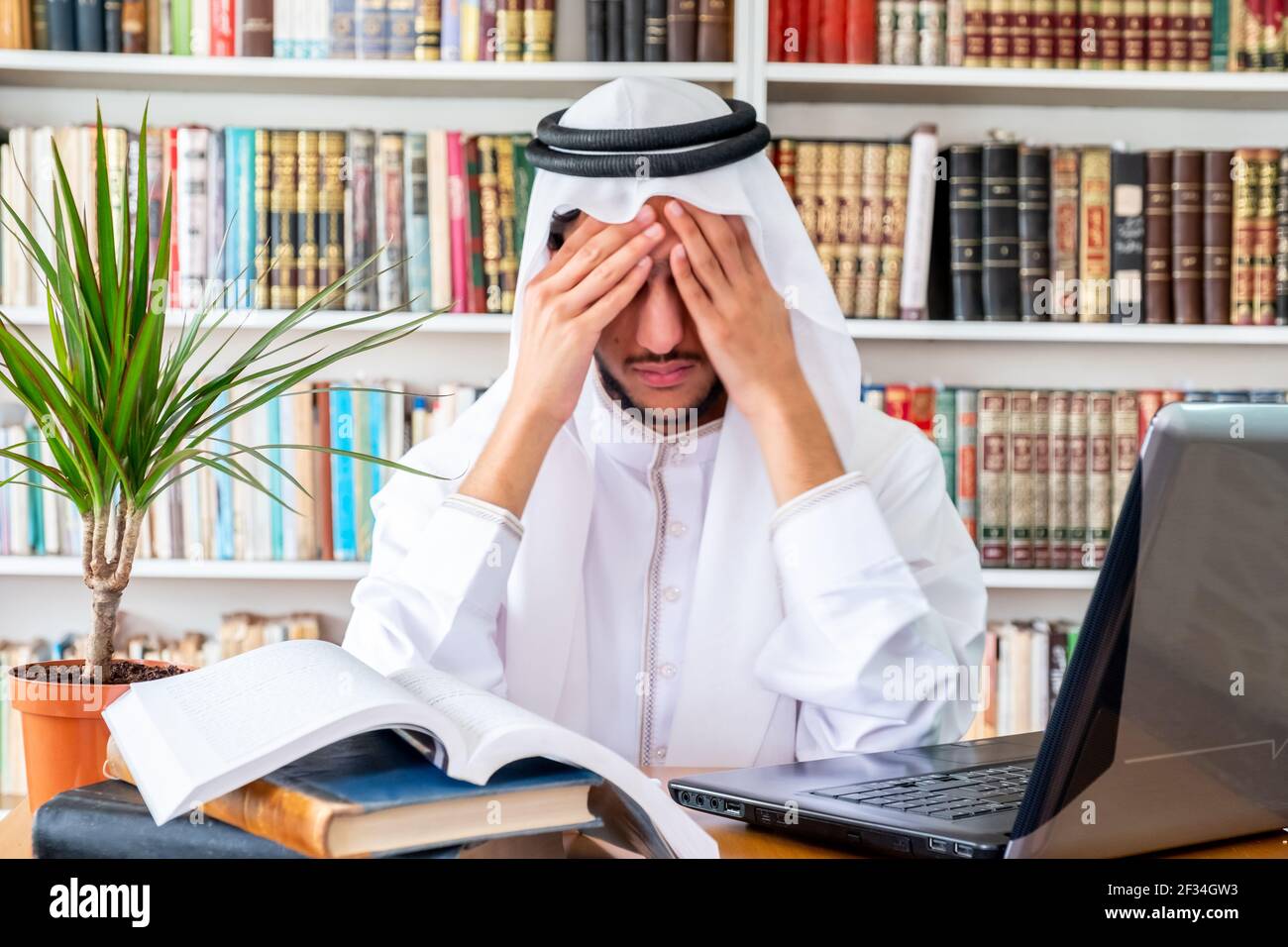 Arabic Muslim man feeling upset while studying online Stock Photo