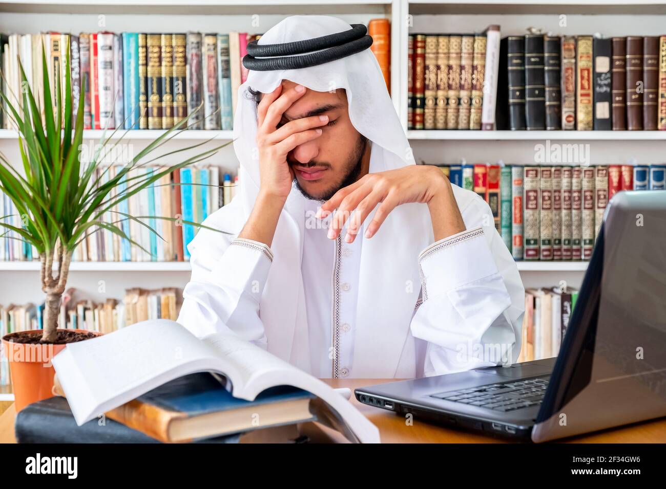 Arabic Muslim man feeling upset while studying online Stock Photo
