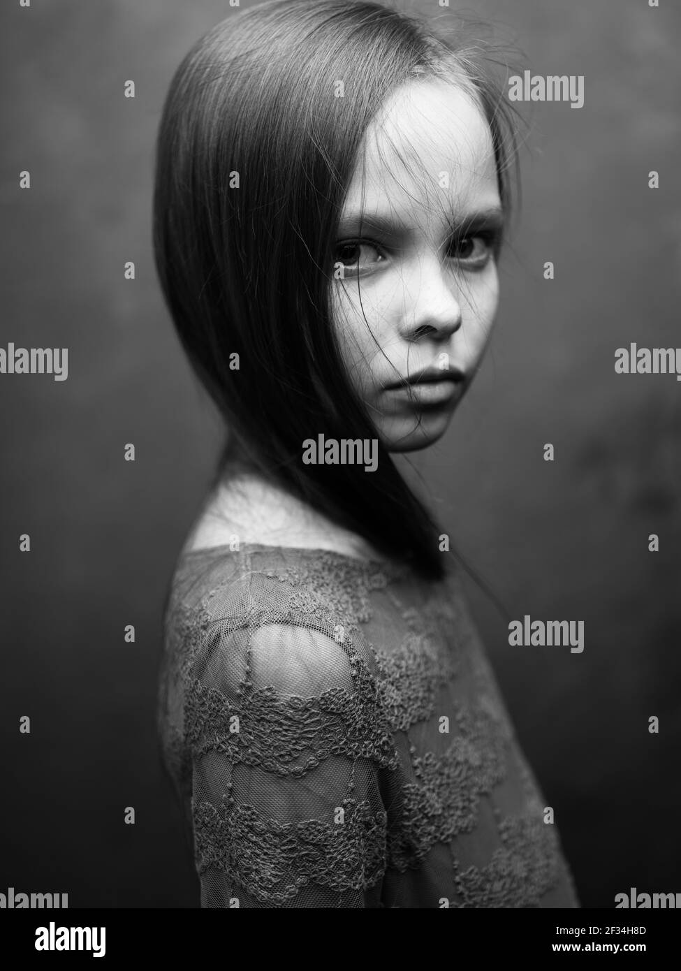 Portrait of a beautiful little girl gray photo dress model side view ...