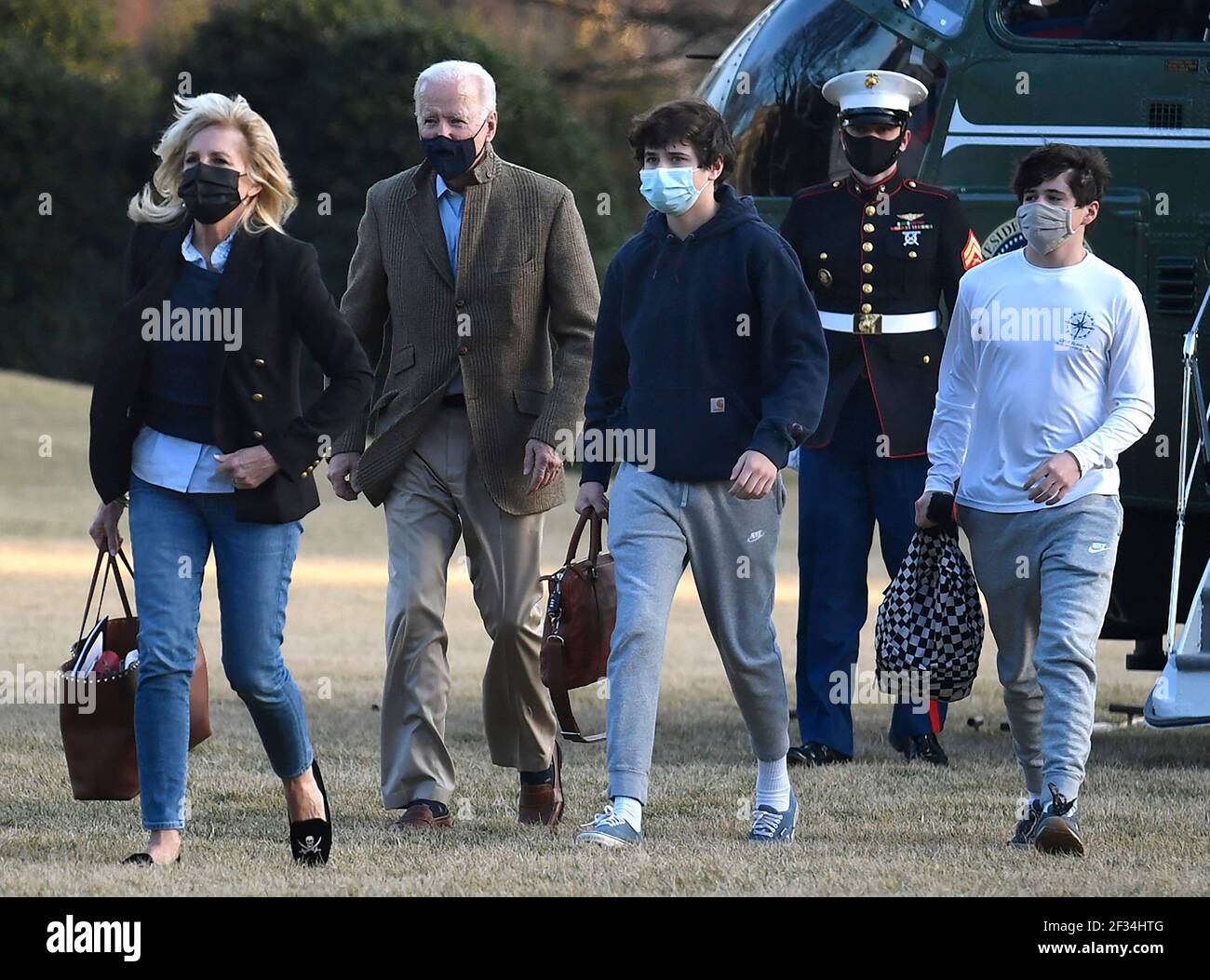 United States President Joe Biden (2nd, L) follows First Lady Dr. Jill  Biden (L) as they and grandchild Hunter (2nd, R) and an unidentified family  friend disembark from Marine One to return