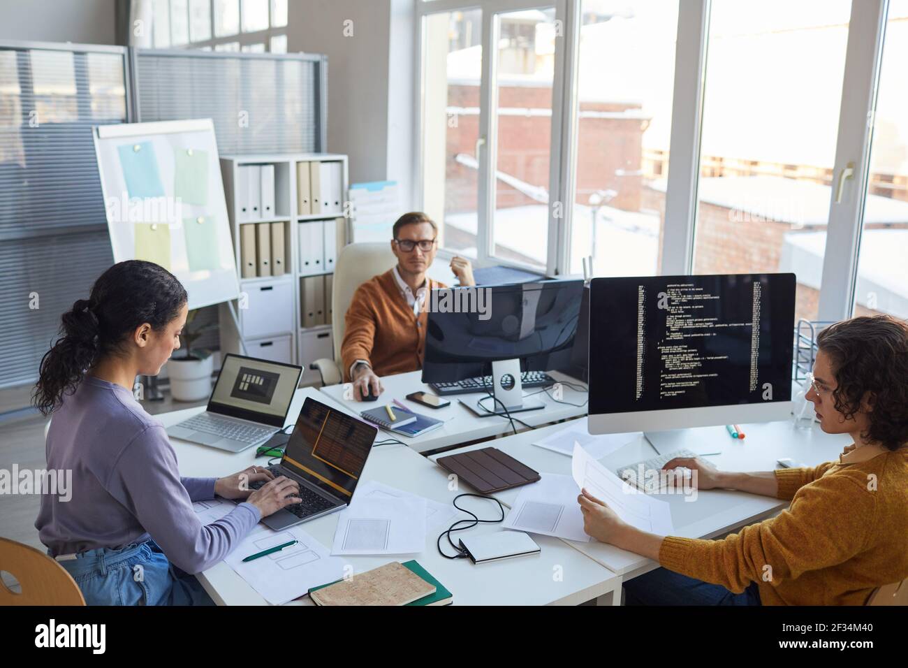 High angle view at diverse software development team using computers and writing code while collaborating on project in modern office, copy space Stock Photo