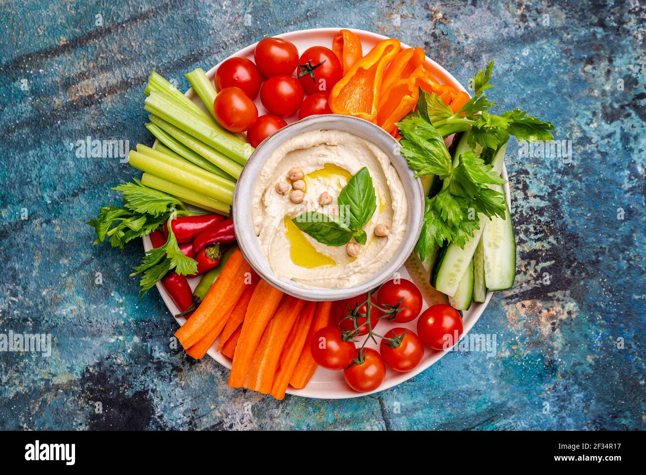 Hummus platter with assorted snacks. Hummus in bowl and vegetables sticks. Plate with Middle Eastern. Party, finger food. Top view. Vegan, hummus dip Stock Photo