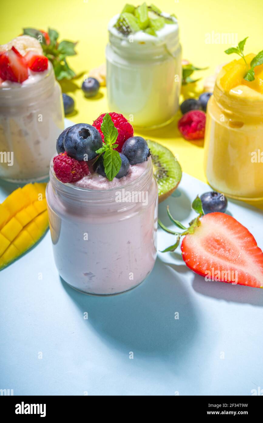 Set of various fruit and berry yogurts in glass jars. Variety healthy