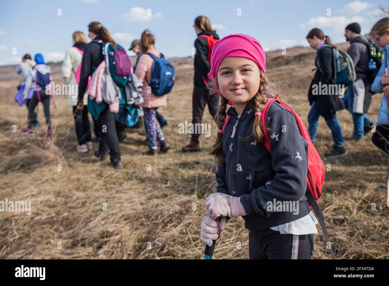 Portrait of adorable hiking little girl on spring day in nature. Stock Photo