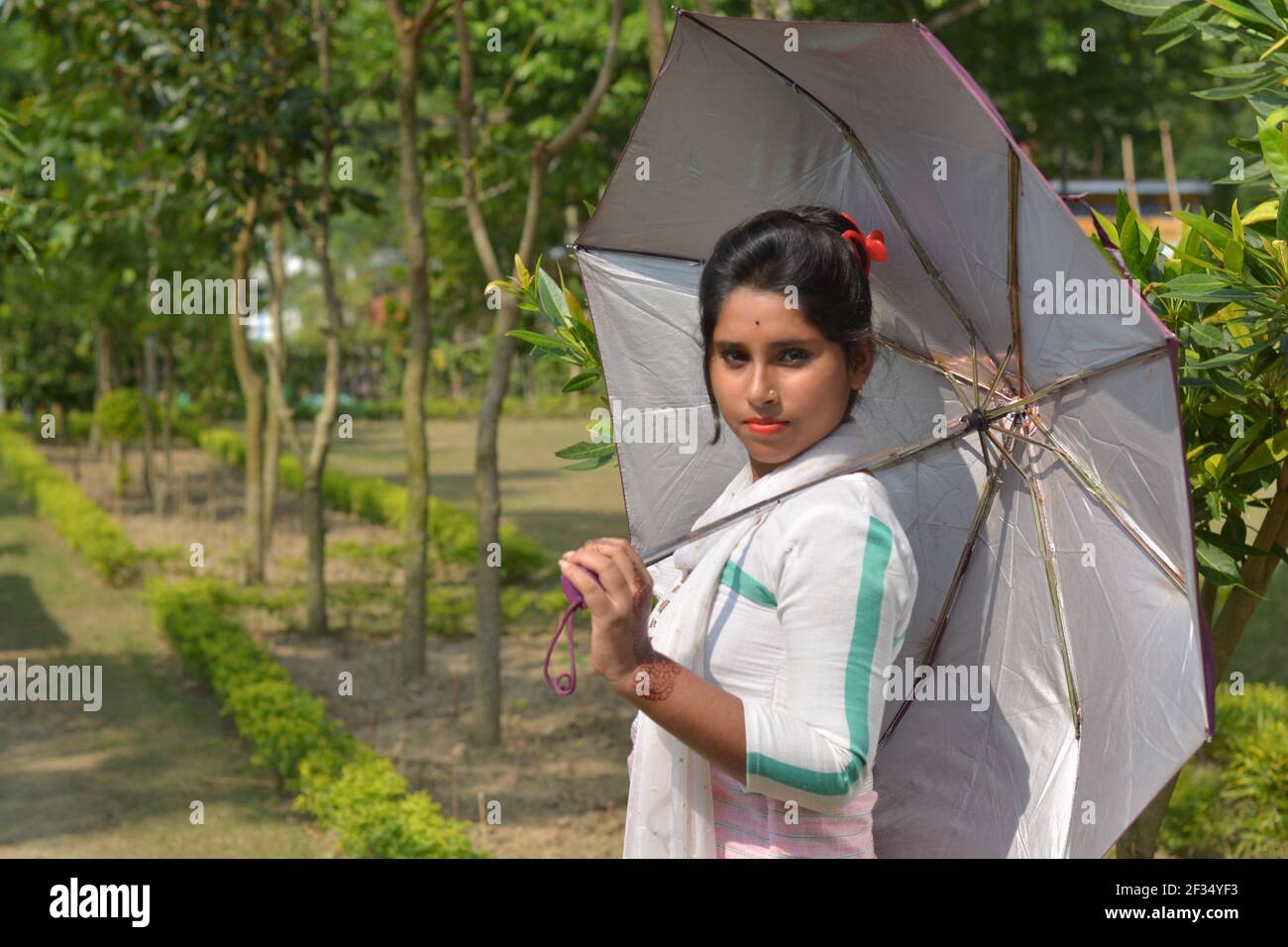 Teenage Indian Bengali girl wearing white cotton salwar holding an