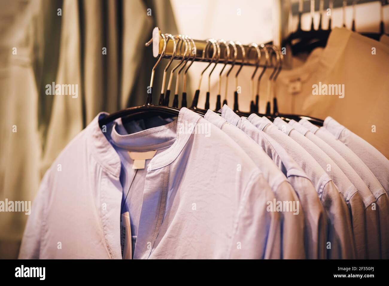 https://c8.alamy.com/comp/2F350PJ/blue-casual-shirts-in-different-sizes-hang-on-hangers-in-a-clothing-store-in-the-mall-shopping-and-sale-2F350PJ.jpg