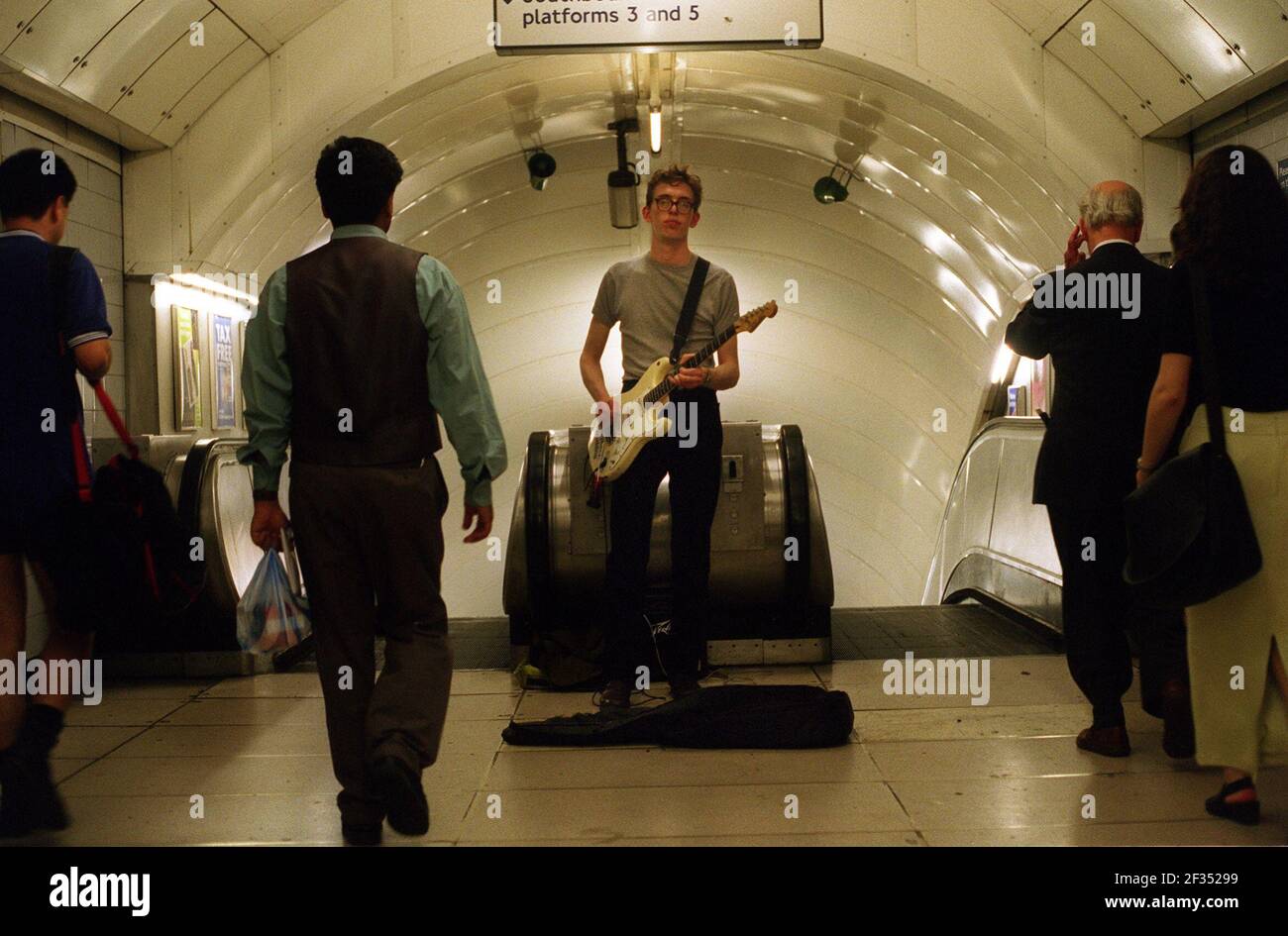 Busker playing guitar at oxford circus  underground station. Stock Photo