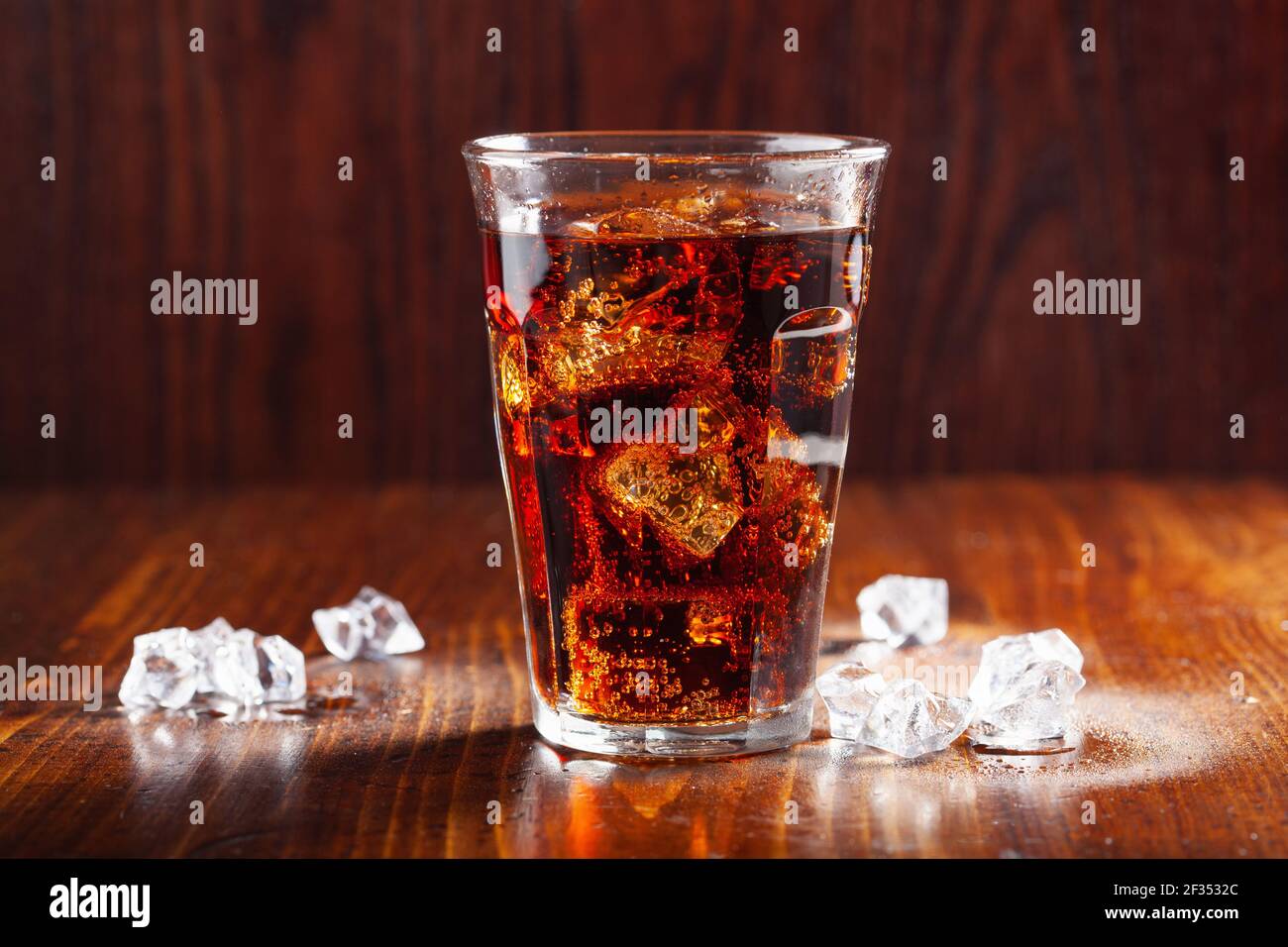 glass of cold cola soft drink with ice on wooden background Stock Photo ...
