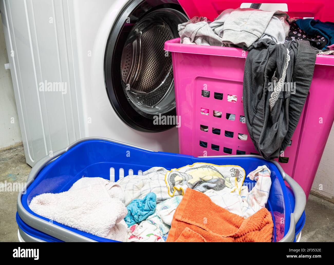 Laundry basket with dirty laundry and washing machine at home Stock Photo