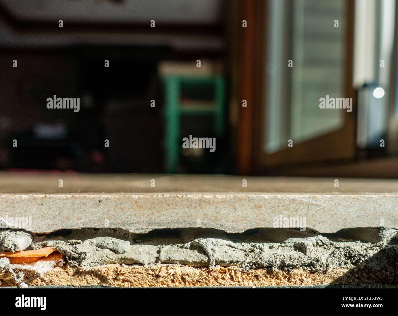 kitchen floor demo with tile, grout, and plywood side view Stock Photo