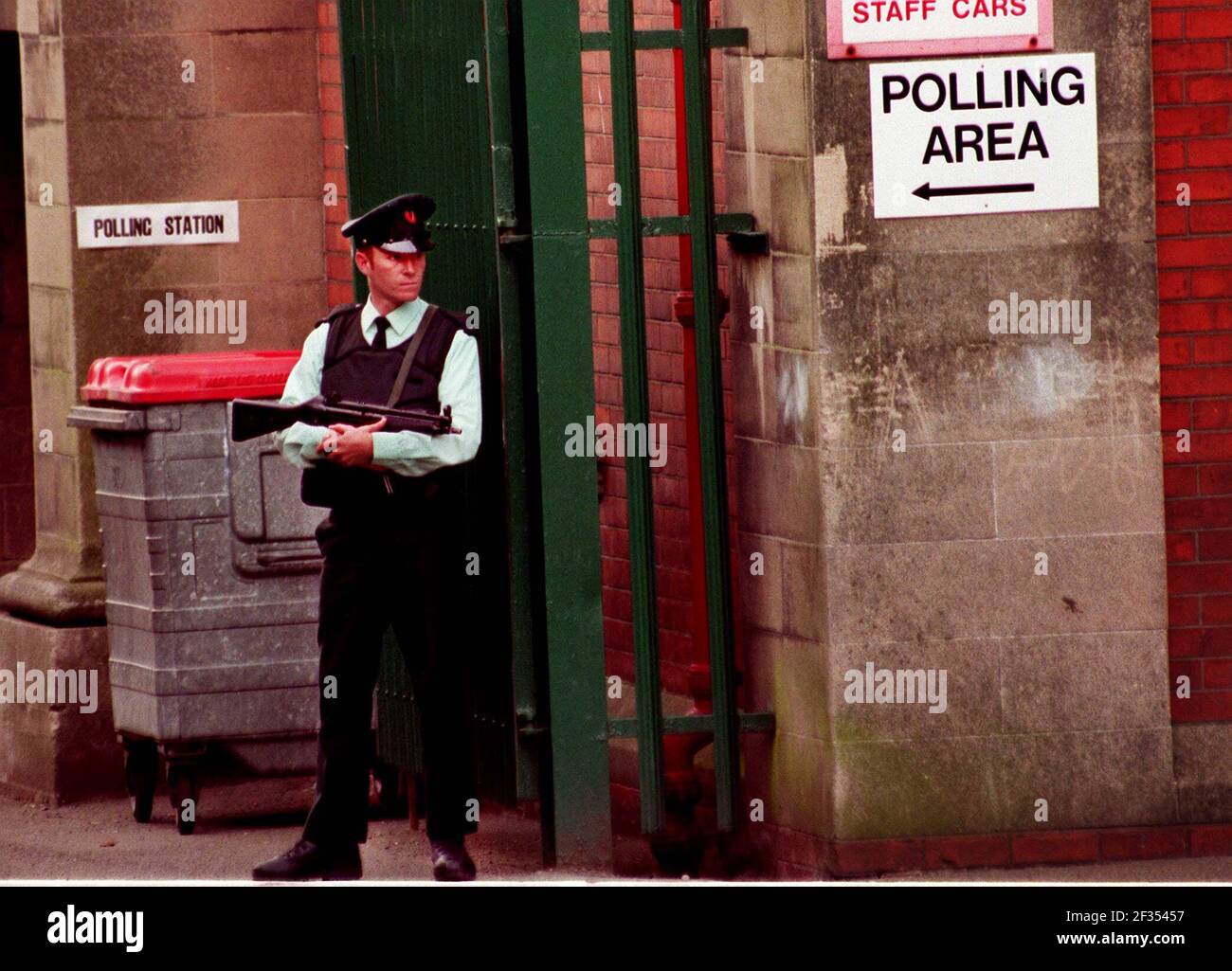 An RUC police guard armed with a Heckler and Koch sub machine gun outside a polling station in Falls Road in Nationalist West Belfast during the Ulster Peace Referendum Stock Photo