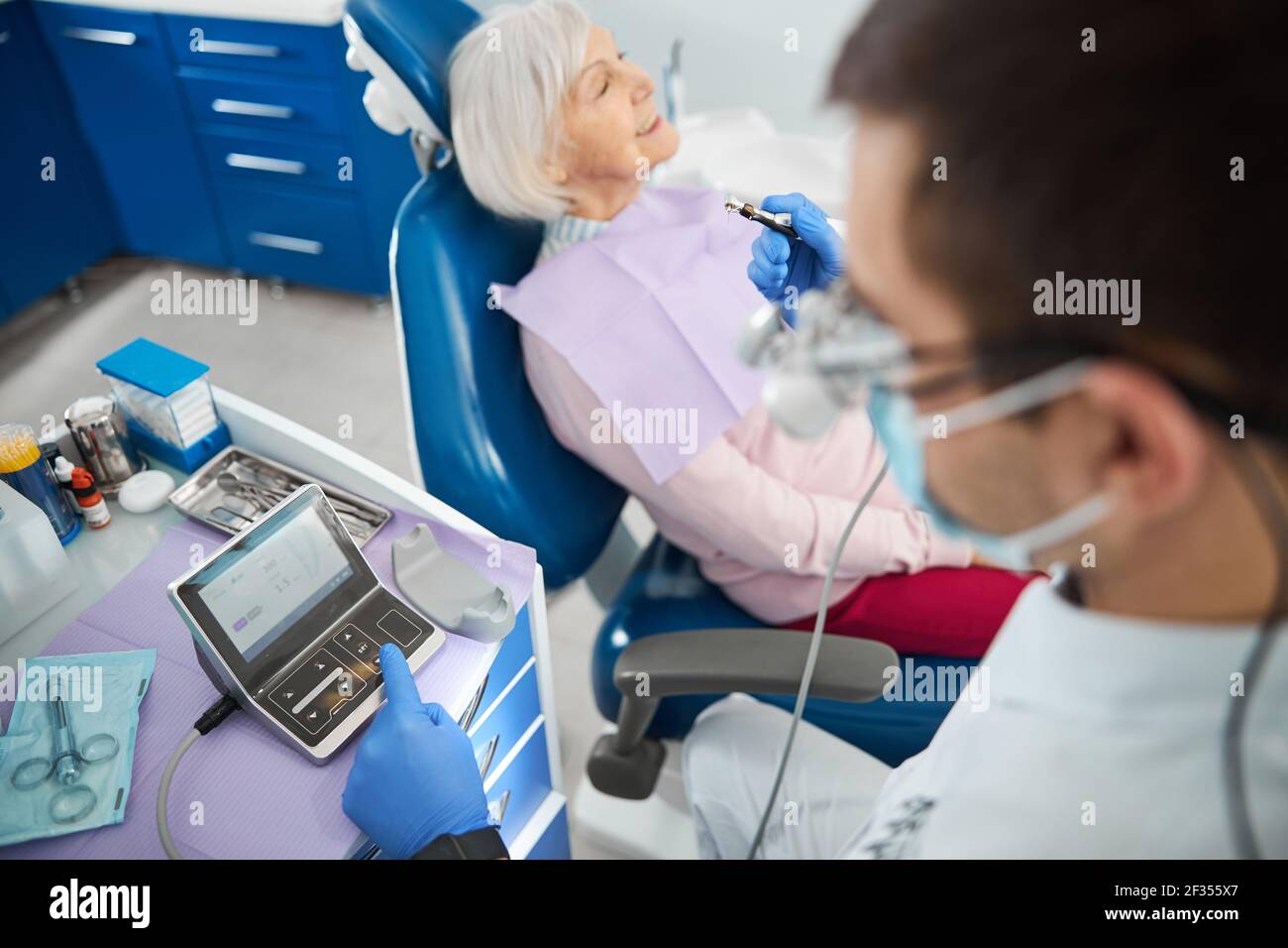 Dentist setting parameters for dental drill in controller Stock Photo