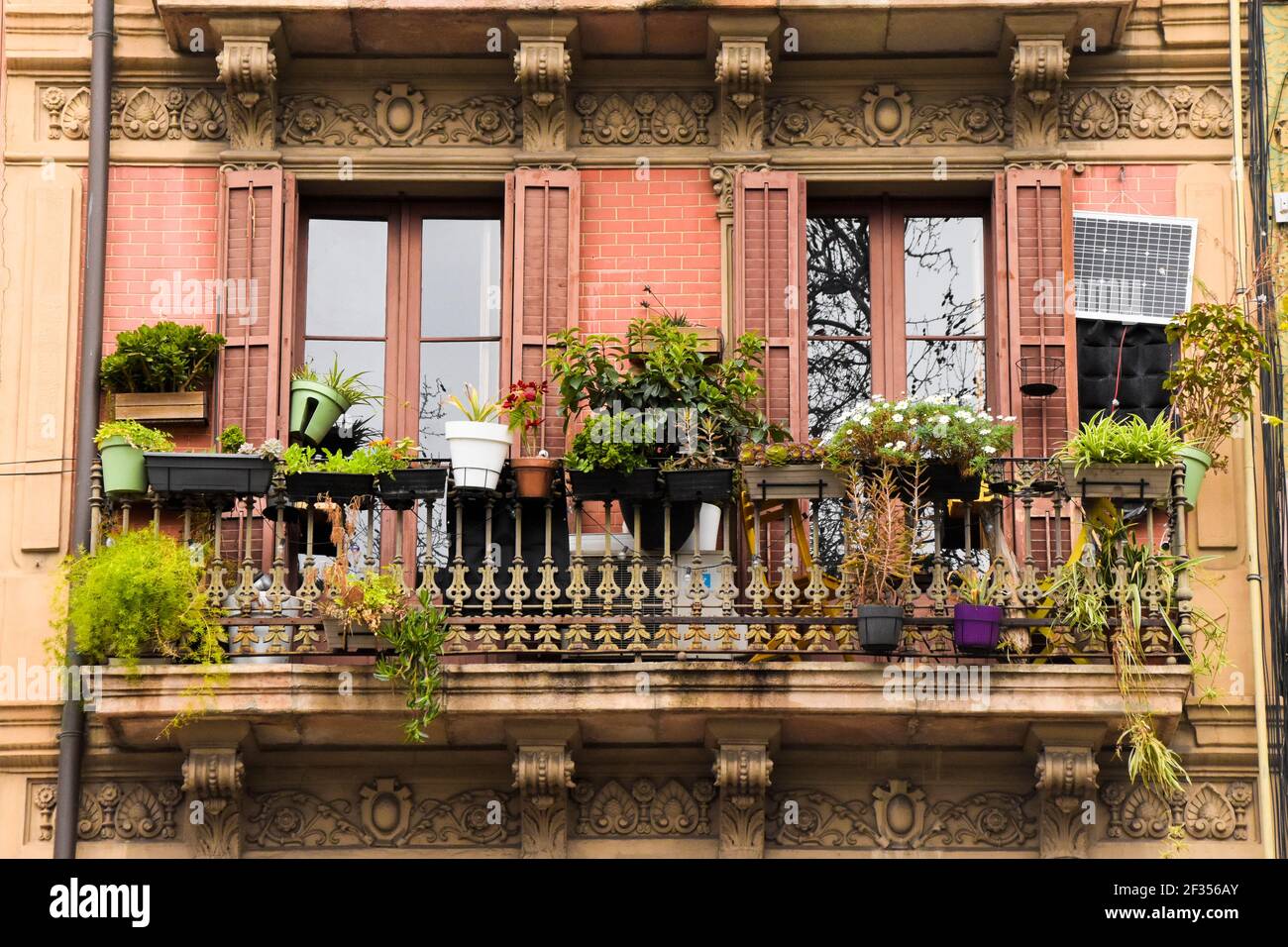 Balcony hanging pots with plants. Old balcony with ornaments on the