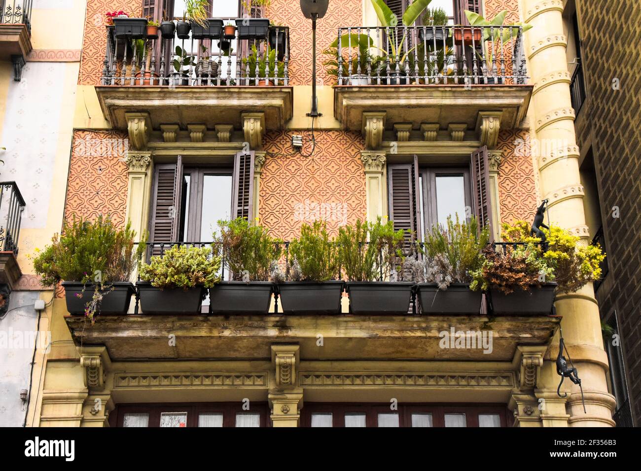 Balcony hanging pots with plants. Old balcony with ornaments on the
