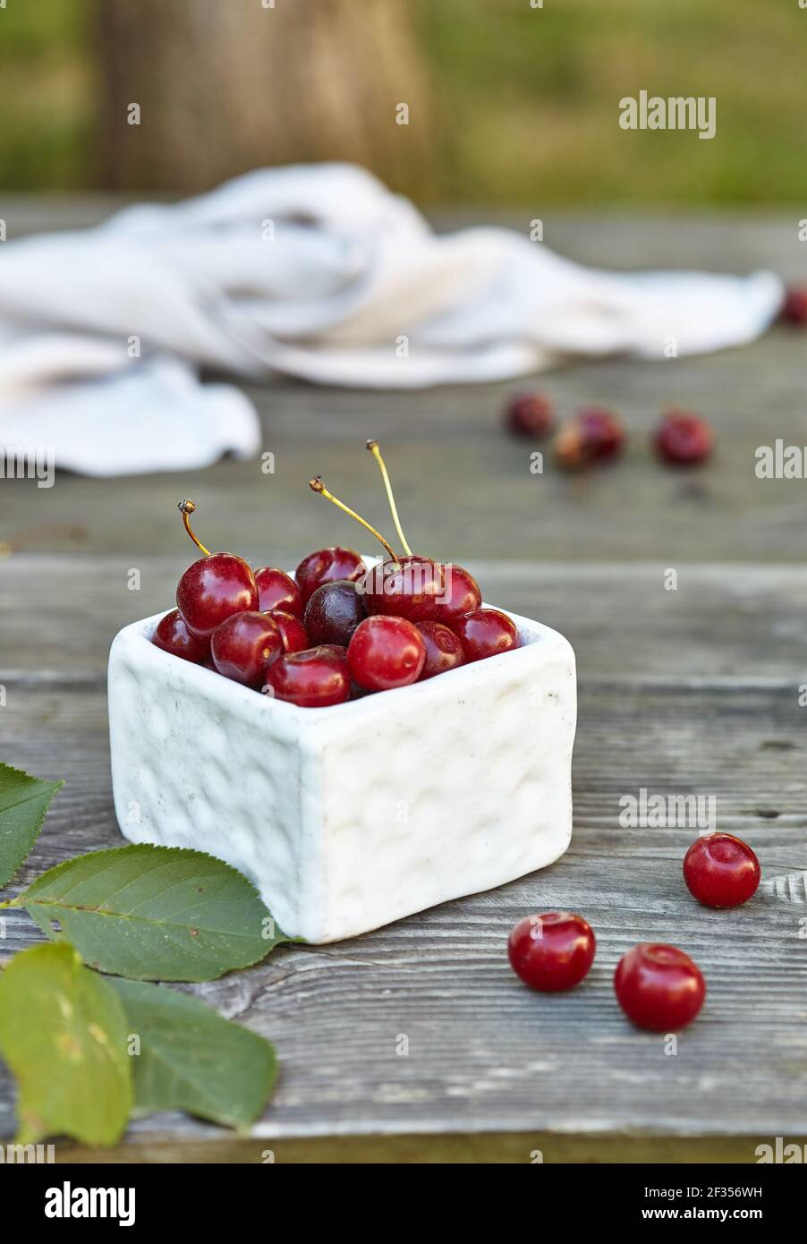 Cherry in a bowl on grey wooden old table. Ripe ripe cherries. Sweet red cherries. Stock Photo