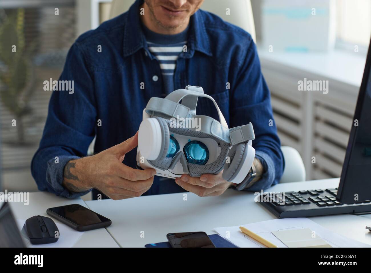 Cropped portrait of unrecognizable IT developer holding VR headset while working on augmenter reality applications, copy space Stock Photo