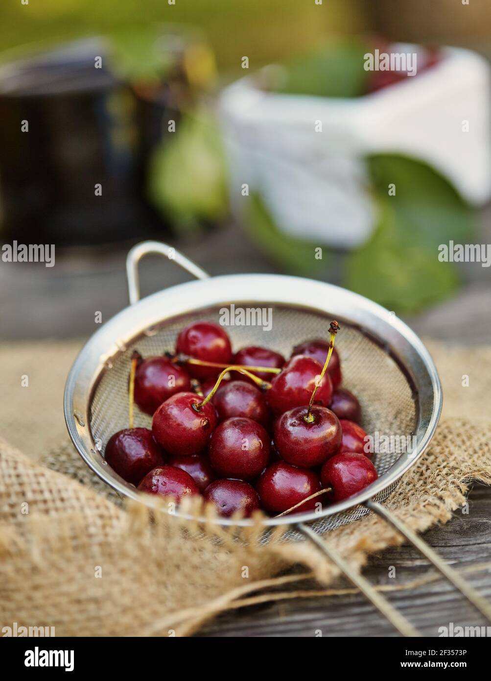 Fresh washed cherries on a sieve. Composition on the table Stock Photo