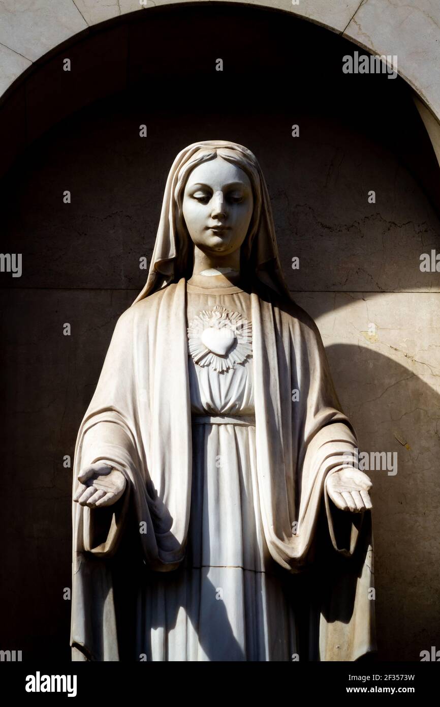 Stone statue of the Virgin Mary with arms outstretched in blessing