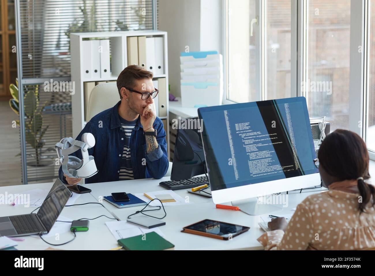 Portrait of modern IT developers using computers for code programming while working on VR software in office, copy space Stock Photo