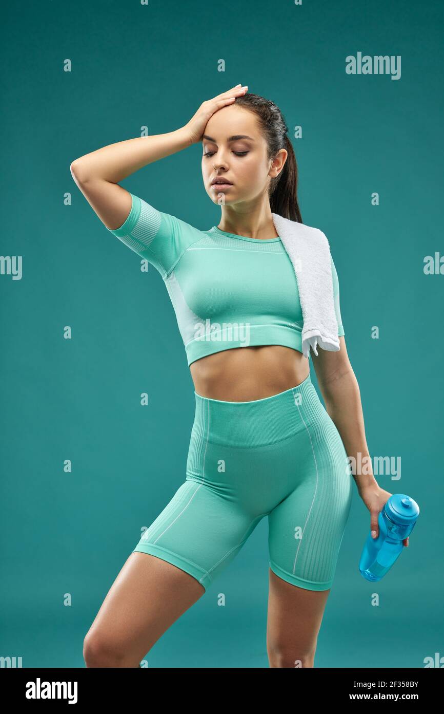 Beautiful young woman in sportswear holding bottle of water Stock Photo