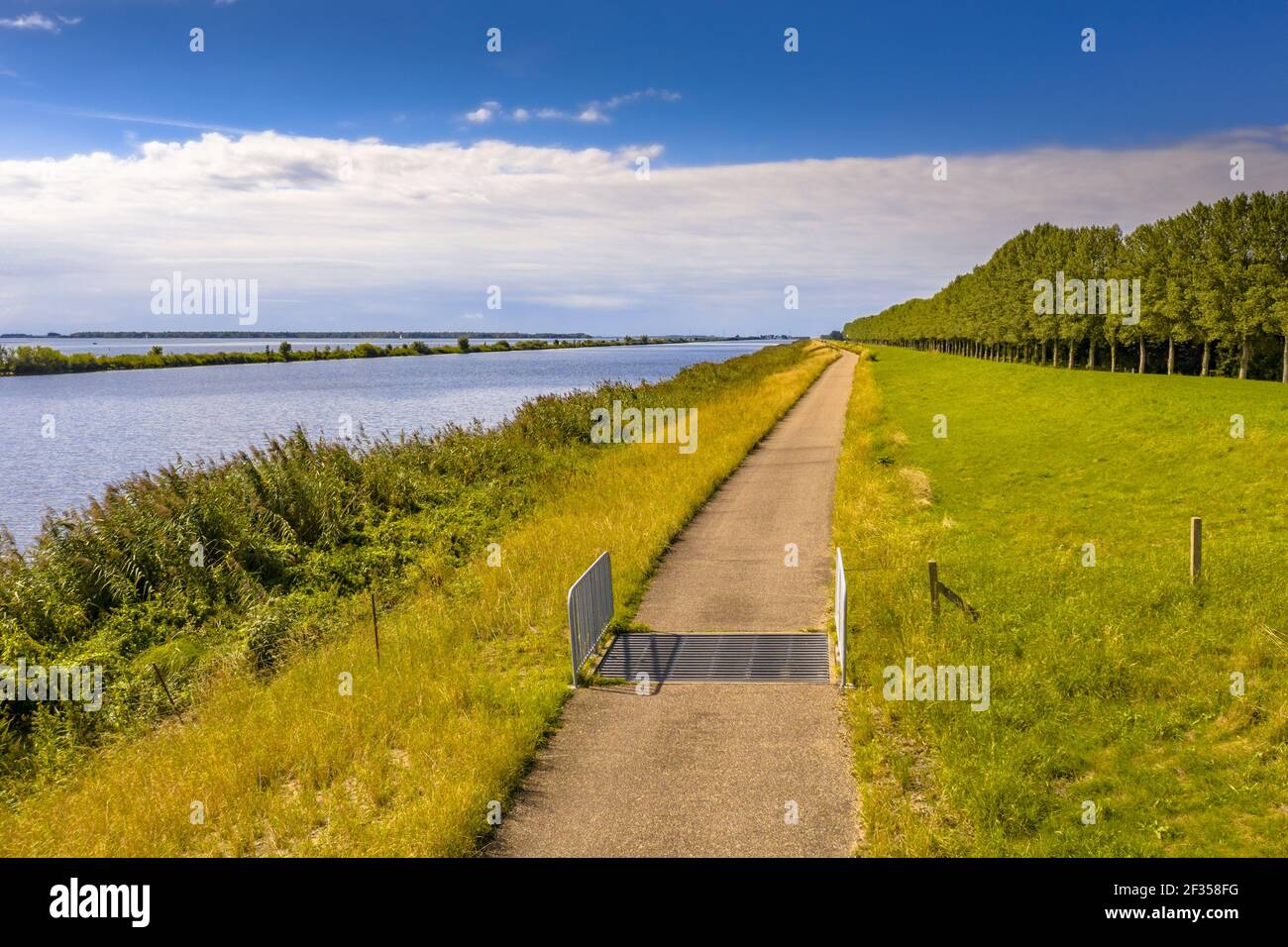 Aerial view of cycling track along Dike and canal near Ens in Flevoland Province, the Netherlands. Stock Photo