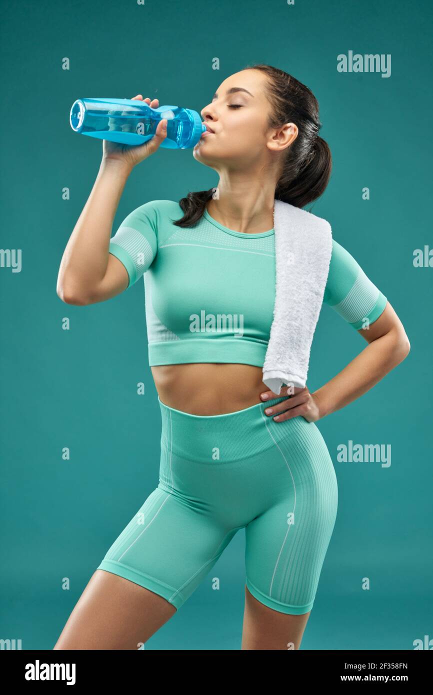Beautiful young woman in sportswear drinking water Stock Photo