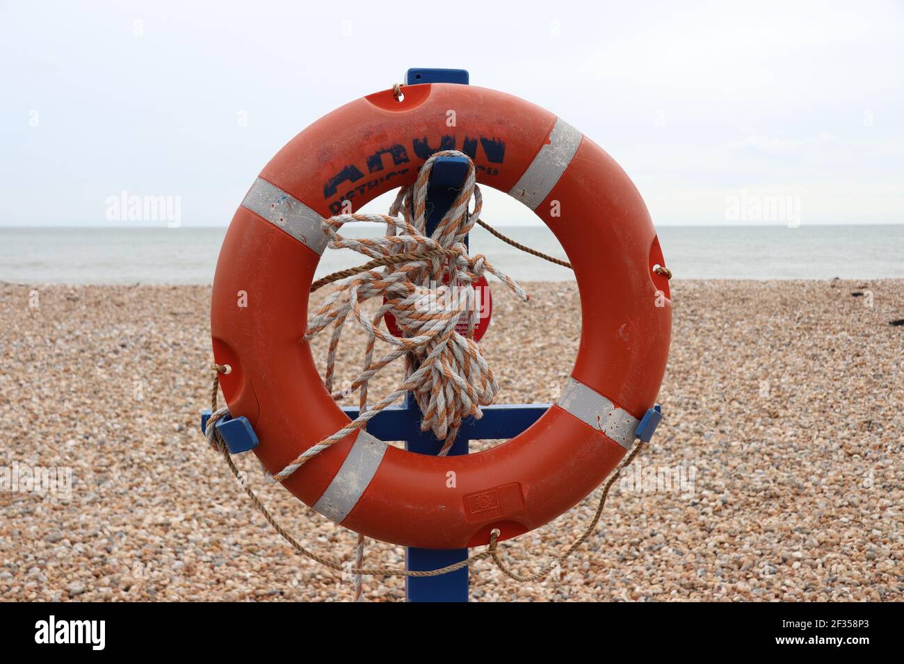 A life bouy or floatation device mounted near the beach Stock Photo
