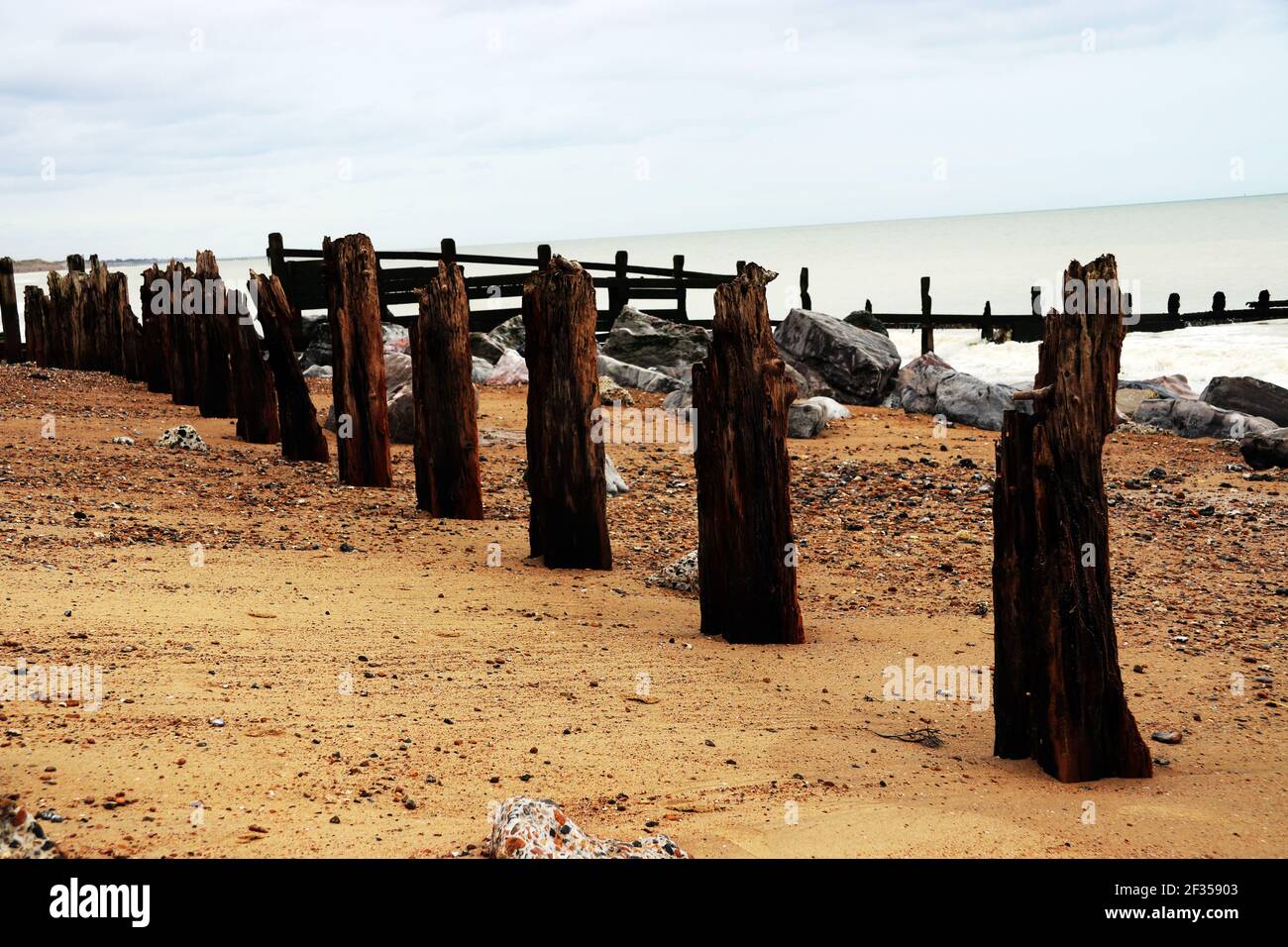 Wooden groynes on a beach showing interesting weathering patterns Stock