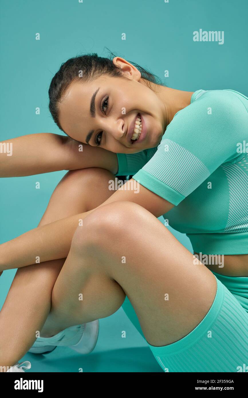 Charming young woman in sportswear posing in studio Stock Photo