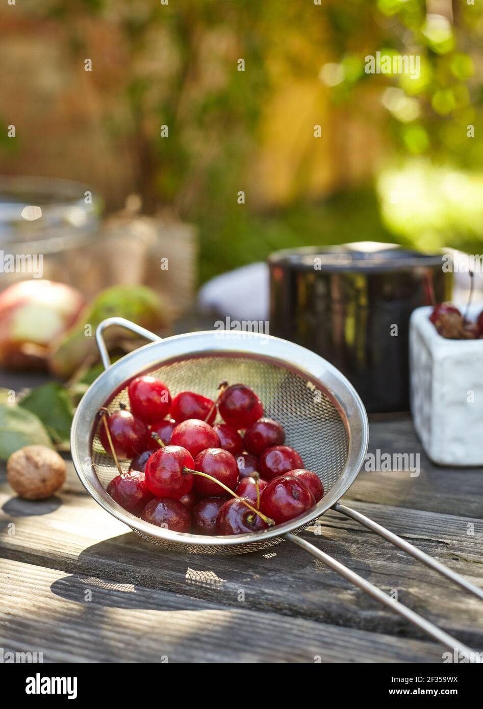 Fresh washed cherries on a sieve. Composition on the table Stock Photo