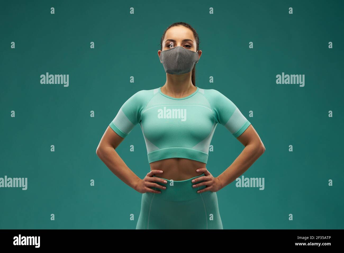Sporty young woman wearing medical face mask Stock Photo