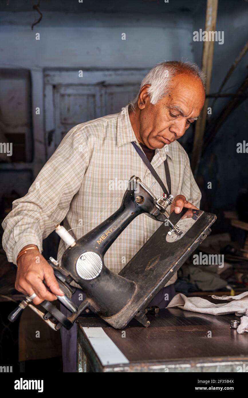 Portrait of elderly man repairing an old sewing machine, Jodhpur, Rajasthan, India Stock Photo