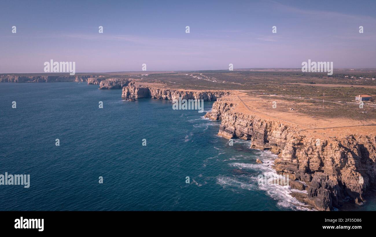A landscape of cliffs covered in greenery surrounded by the sea on a ...