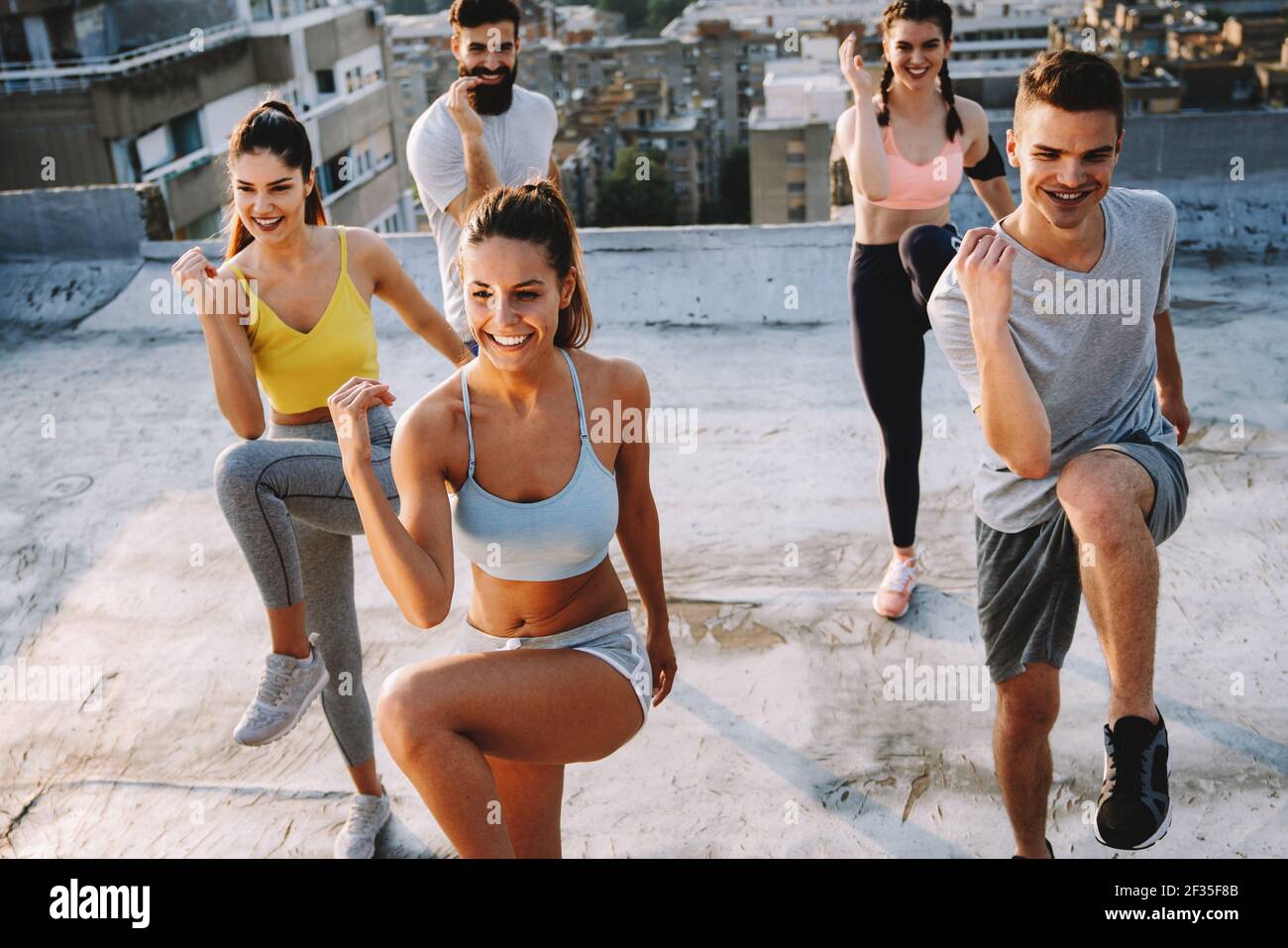 Fitness, sport, training and lifestyle concept. Group of fit people exercising outdoor Stock Photo