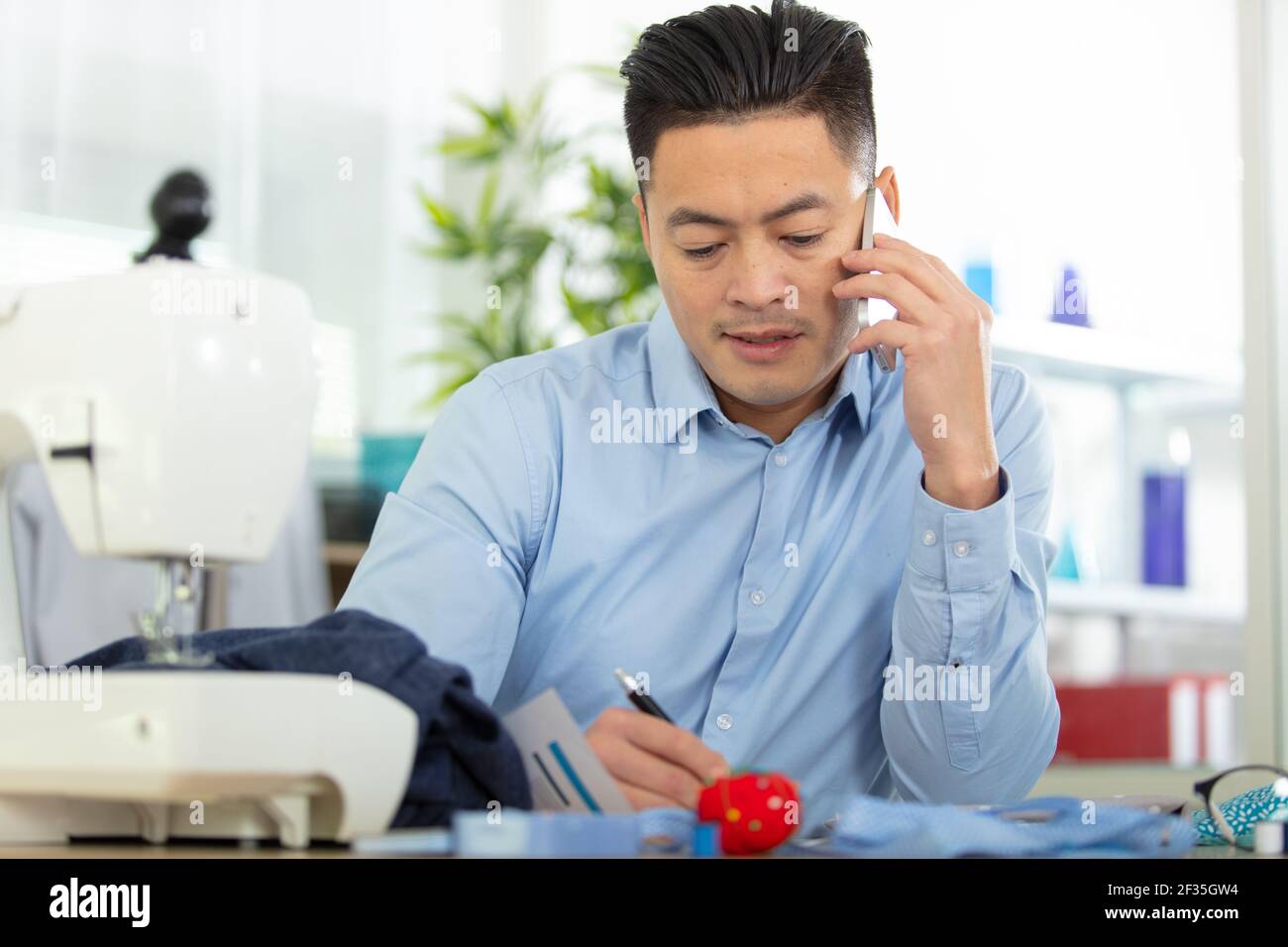 dressmaking design service worker talking phone Stock Photo