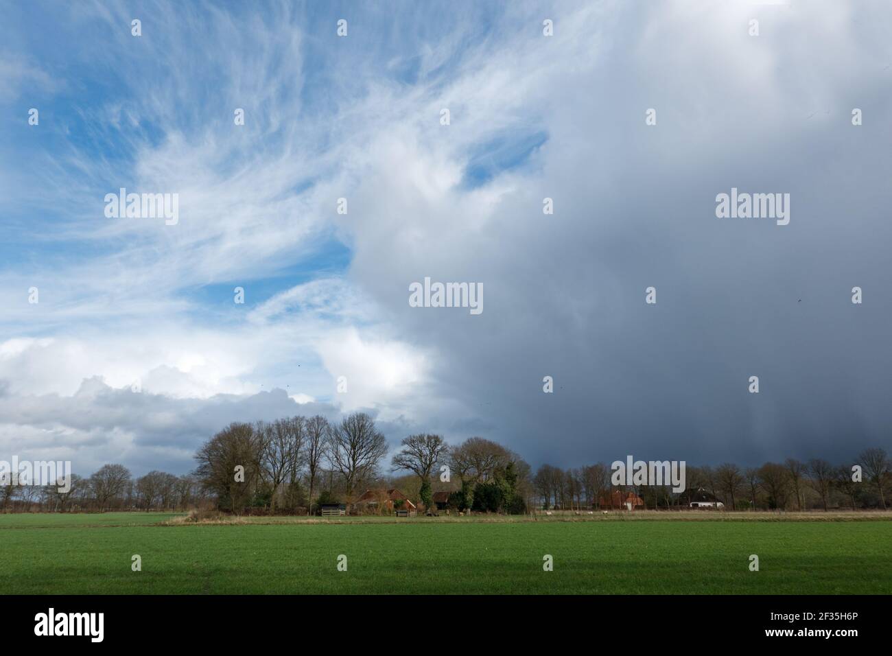 Rural landscape with small farmhouses in the Netherlands under beautiful wild storm clouds Stock Photo