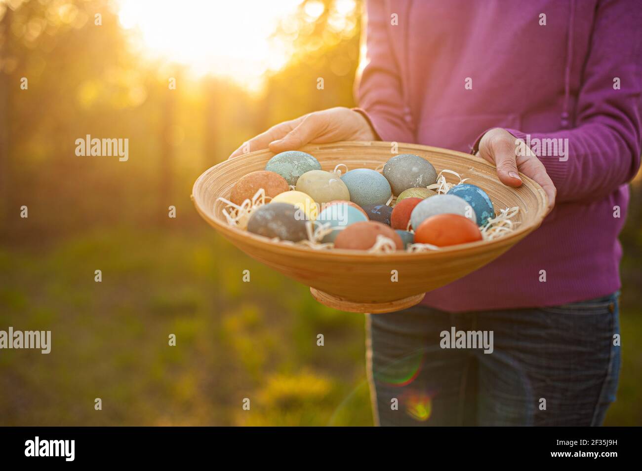 Girl holding a wooden plate with easter eggs Stock Photo