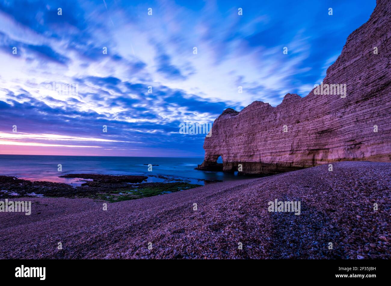 Low angle view of beach and tall chalk cliffs with natural arch Porte d ...