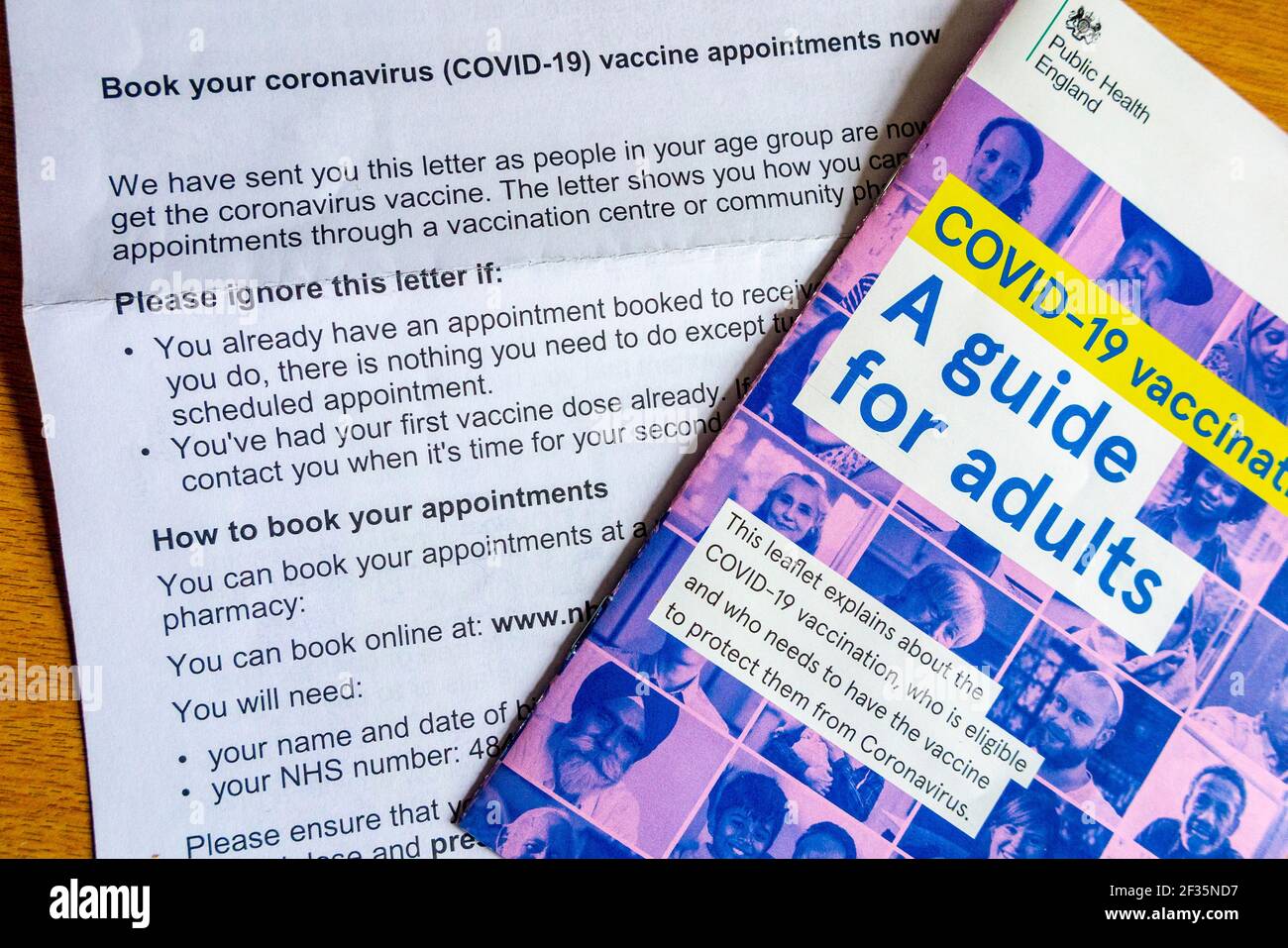 Leaflet Covid-19 Vaccination A Guide for Adults sent by Public Health England with letter explaining how to book coronavirus vaccination in March 2021 Stock Photo