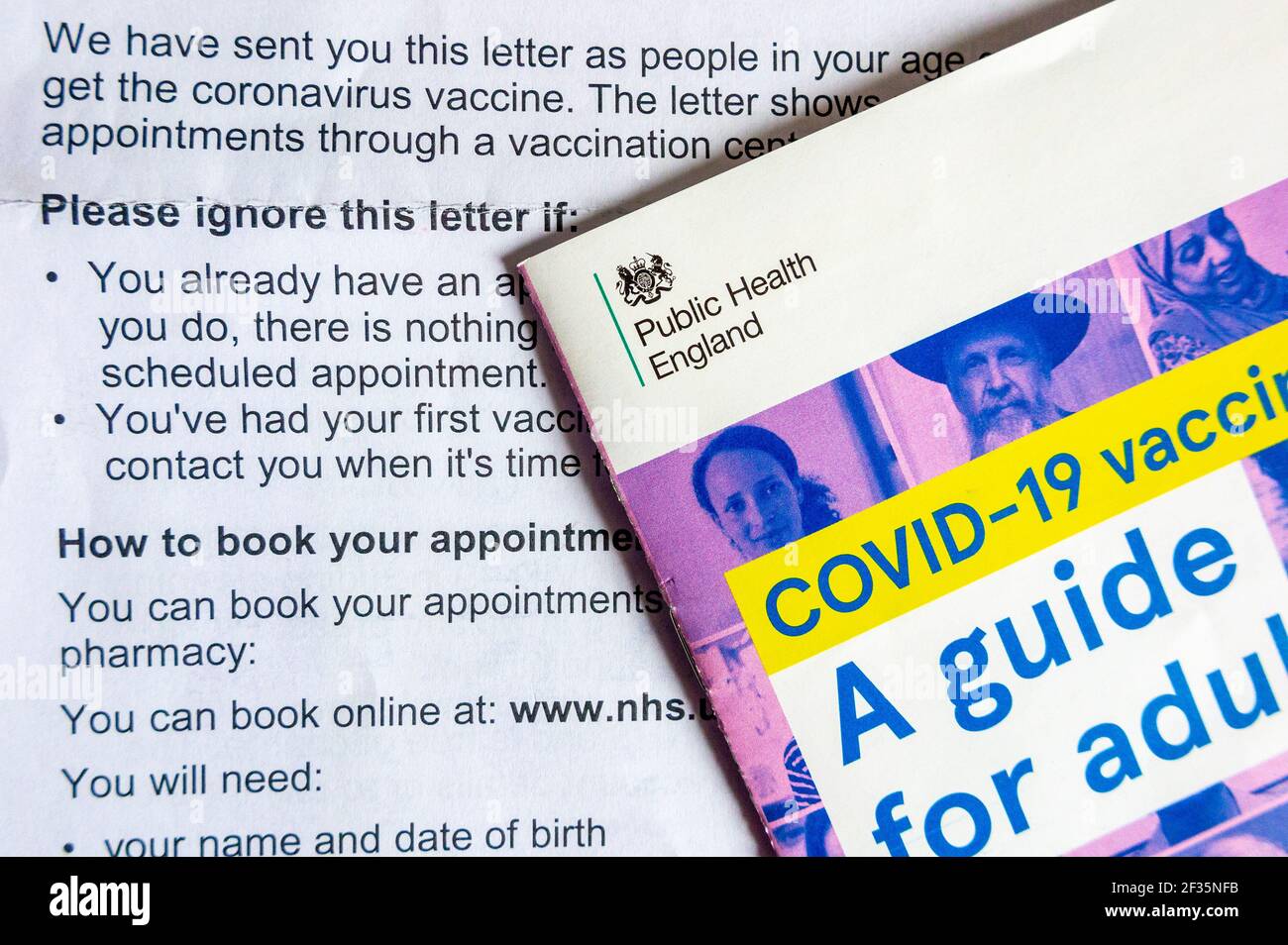 Leaflet Covid-19 Vaccination A Guide for Adults sent by Public Health England with letter explaining how to book coronavirus vaccination in March 2021 Stock Photo