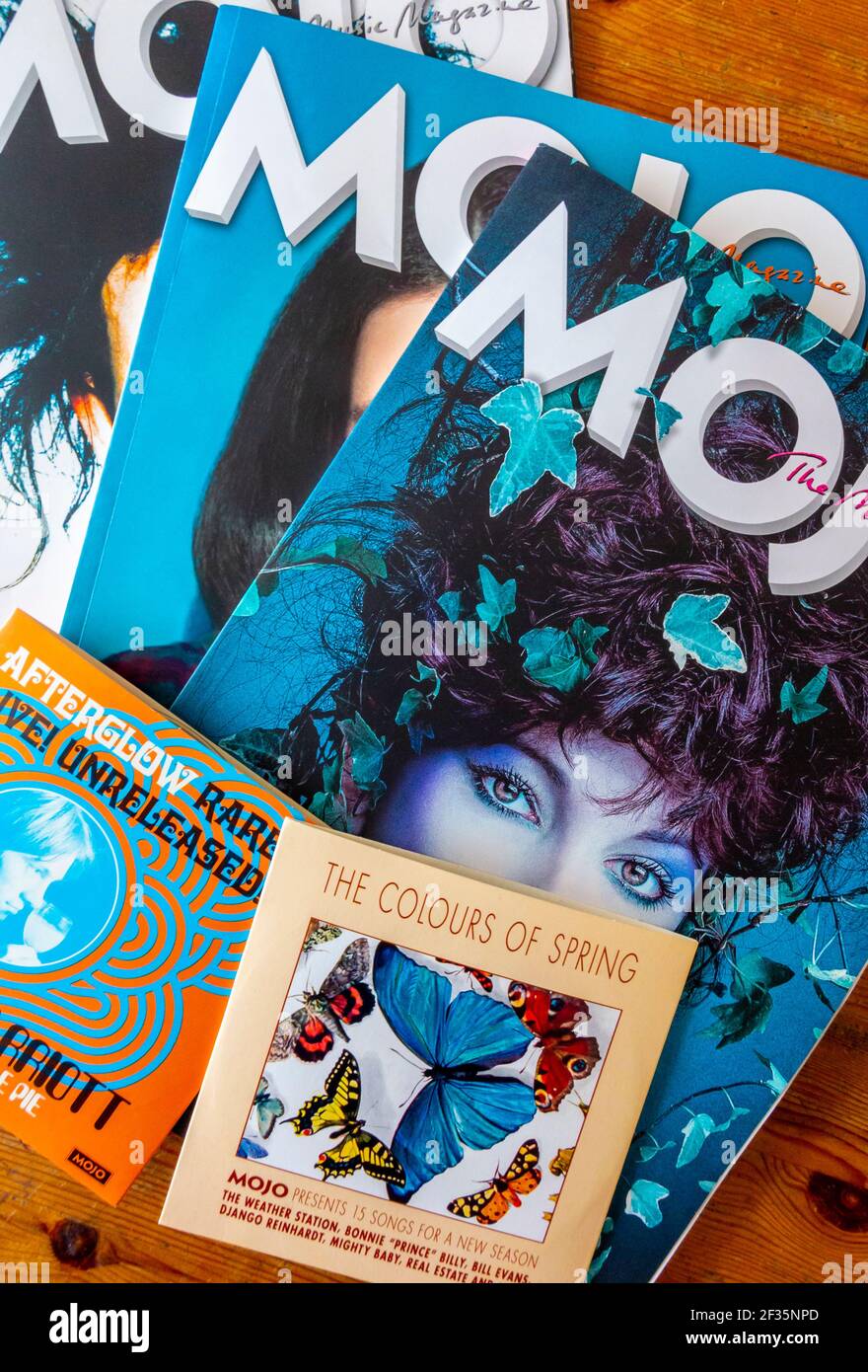 Issues of Mojo a British music magazine that covers heritage rock and new music with a free cover mounted CD that is given away with each copy. Stock Photo